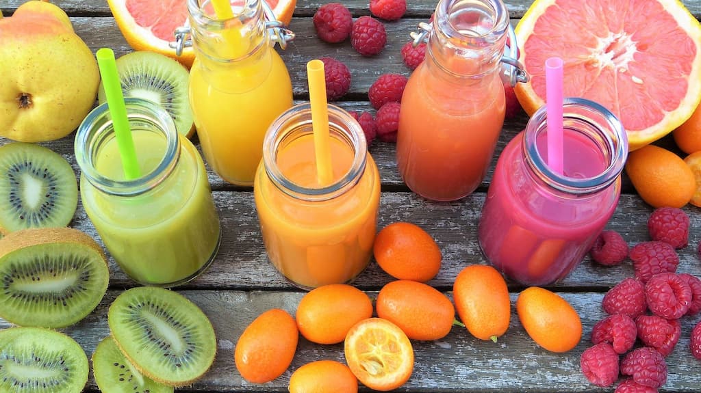 Vitamine și minerale pentru vârsta a treiaitamine și minerale pentru vârsta a treiaitamine și minerale pentru vârsta a treia prin diferite smoothies colorate în sticle și pai.