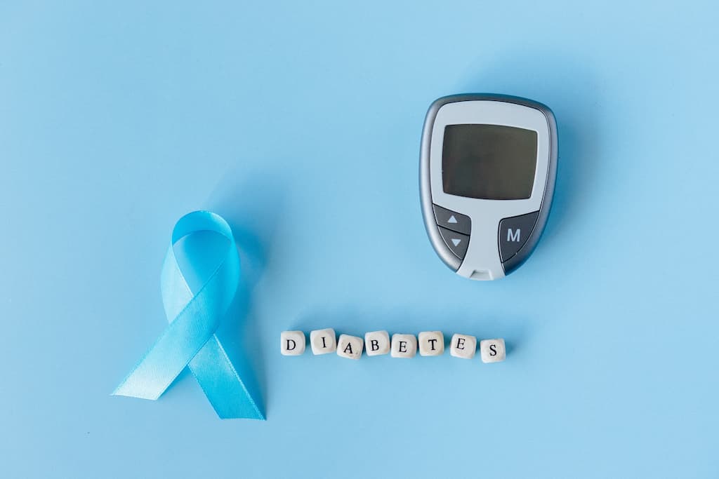Aparat de măsurat glicemia peste 50 de ani pe fundal albastru deschis cu litere care arată diabetes.
